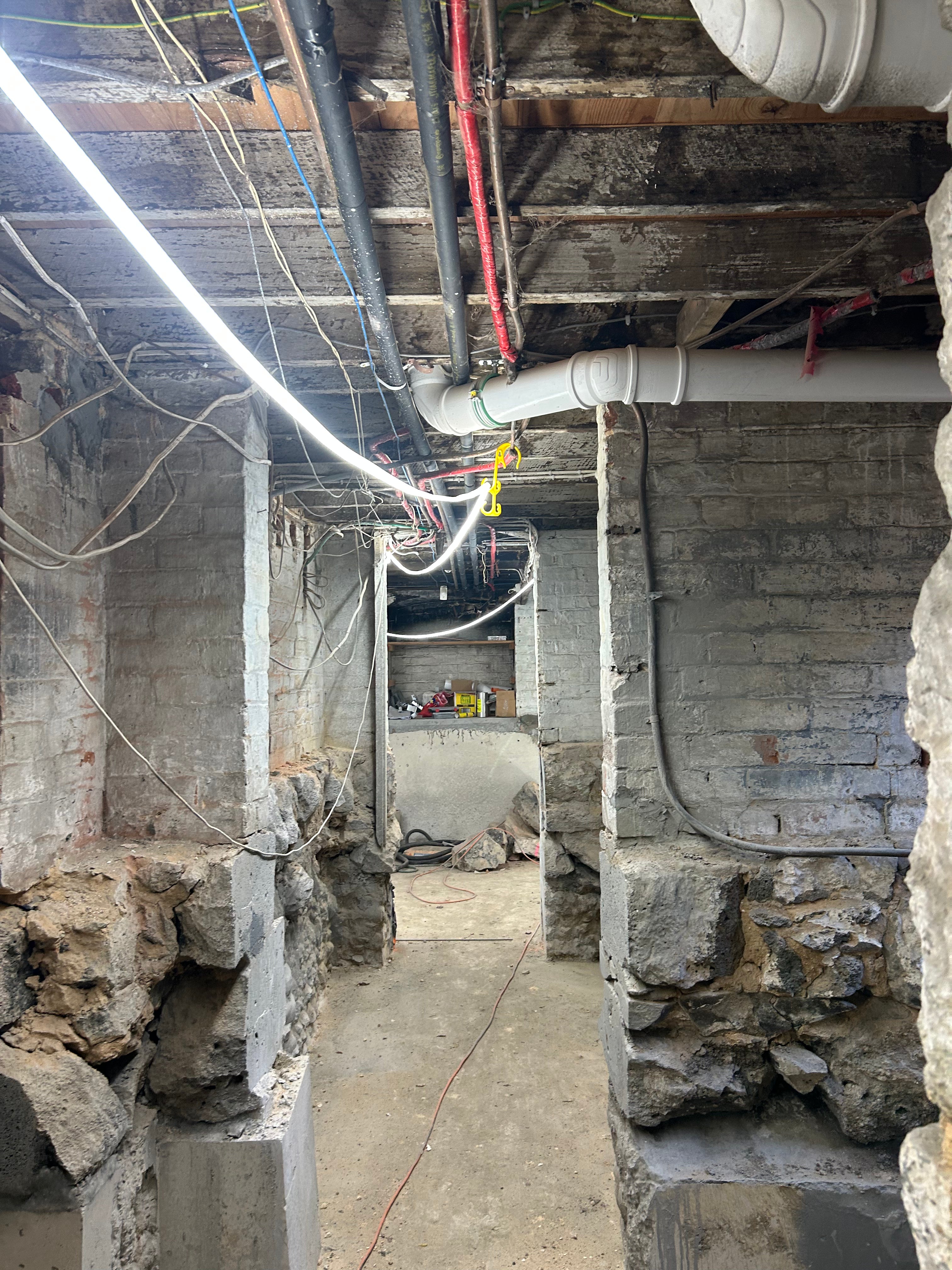 Underground basement work space featuring LED construction lighting strip mounted on ceiling 